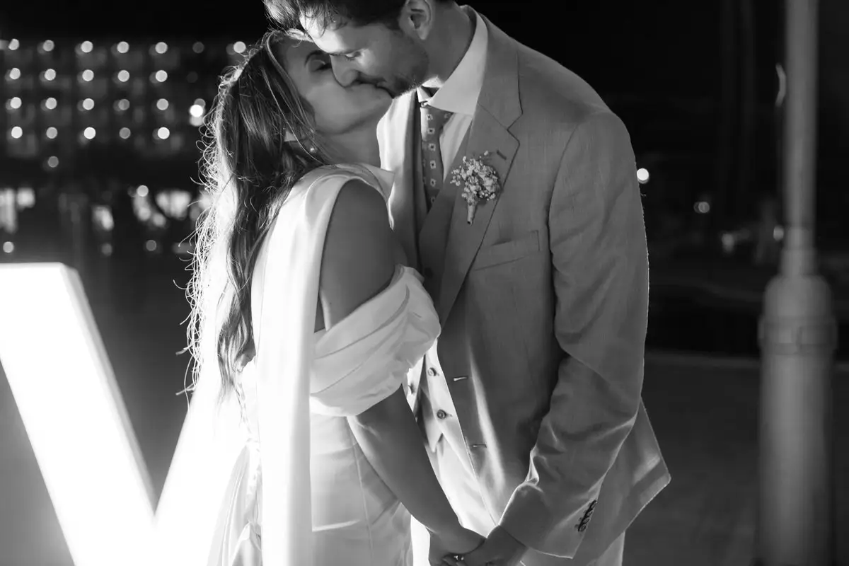 Un beso de los novios durante la fiesta de una boda en L’Ametlla de Mar