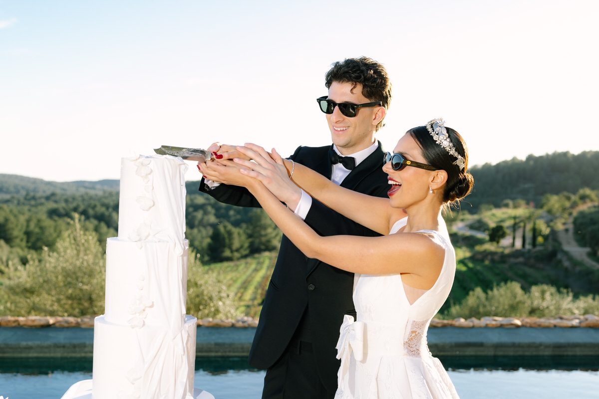 pareja de novios cortando el pastel nupcial en Masia Cabellut